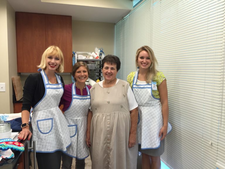 Dietitians wearing aprons posing with apron designer